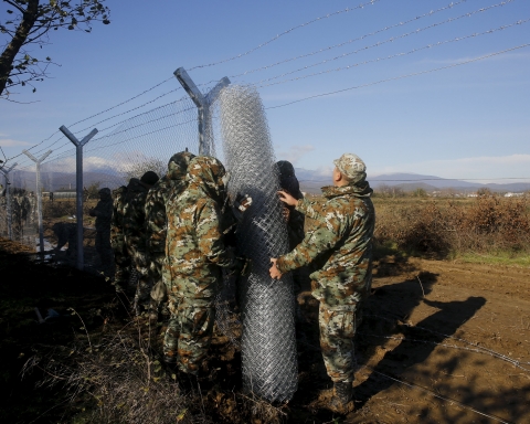 Macedonian soldiers build up a metal fence at the Greek-Macedonian border near the Greek village of Idomeni, November 28, 2015. Soldiers in Macedonia began erecting a metal fence on Saturday on the country's southern border with Greece, described by an official as a "preventive" measure to better control the flow of migrants across the Balkans. Picture taken from the Greek side of the border. REUTERS/Yannis Behrakis