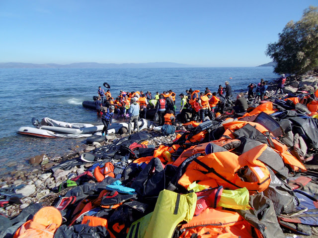Πρόσφυγες και μετανάστες φτάνουν με φουσκωτή βάρκα στην Σκάλα Συκαμνιάς της Λέσβου,  που είναι καλυμμένη από σωσίβια, την Τρίτη 3 Νοεμβρίου 2015. Περισσότερες από 7.000 μετανάστες και πρόσφυγες ήταν εγκλωβισμένοι, σύμφωνα με στοιχεία της Αστυνομικής Διεύθυνσης Λέσβου, σήμερα το πρωί, στο λιμάνι της Μυτιλήνης, αφού λόγω της απεργίας της ΠΝΟ δεν πραγματοποιείται από τα χαράματα χθες Δευτέρα κανένα δρομολόγιο, τακτικό ή έκτακτο, προς τον Πειραιά ή την Καβάλα.  Σήμερα, με την καλυτέρευση των καιρικών συνθηκών, ιδιαίτερα στη βόρεια Λέσβο, περνάν κατά πολλές εκατοντάδες άνθρωποι από τα απέναντι παράλια. Η αυξημένη αυτή ροή δείχνει ότι πιθανά ο αριθμός των εγκλωβισμένων στη Λέσβο μεταναστών και προσφύγων θα φτάσει τα δυσθεώρητα ύψη των αρχών του περασμένου Σεπτεμβρίου.  ΑΠΕ- ΜΠΕ/ ΑΠΕ-ΜΠΕ /ΣΤΡΑΤΗΣ ΜΠΑΛΑΣΚΑΣ