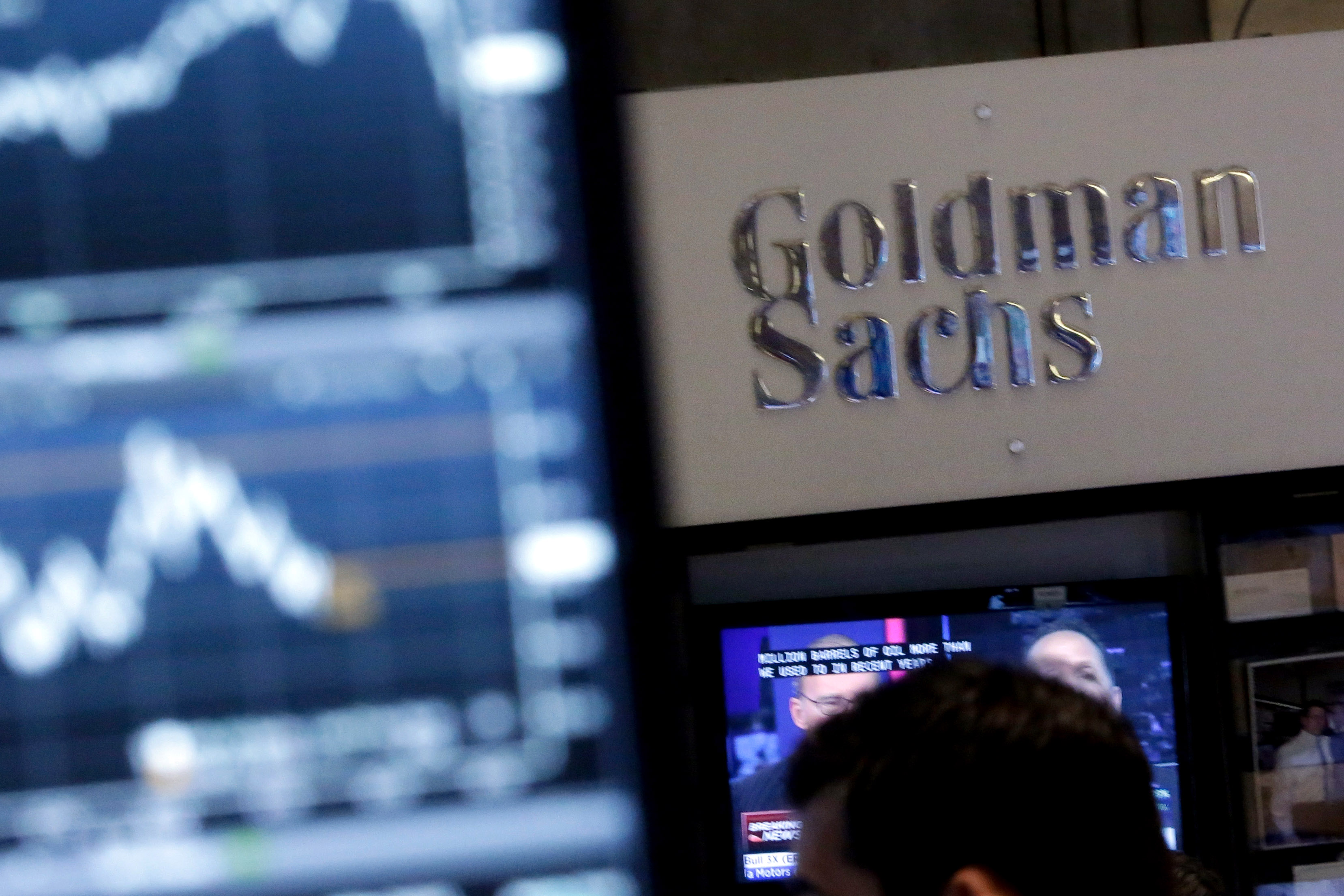 FILE - In this Oct. 16, 2014 file photo, a screen at a trading post on the floor of the New York Stock Exchange is juxtaposed with the Goldman Sachs booth. The Goldman Sachs Group Inc. reports quarterly financial results before the market opens on Friday, Jan. 16, 2015. (AP Photo/Richard Drew, File)