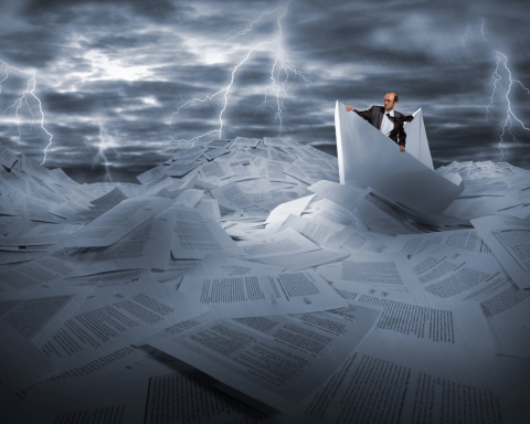 Businessman sailing in stormy papers sea