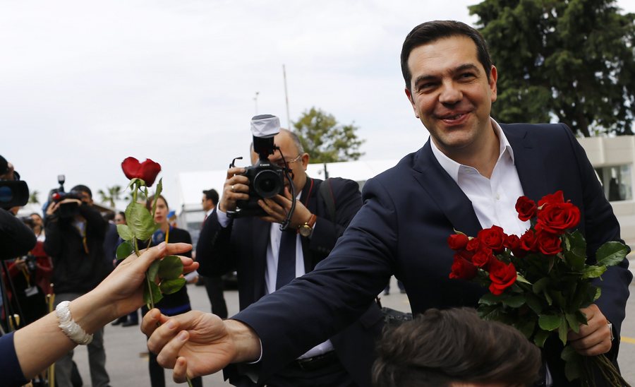 epa05200728 Greek Prime Minister Alexis Tsipras gives flowers to female journalists before meeting Turkish Prime Minister Ahmet Davutoglu (unseen), in Izmir, Turkey, 08 March 2016. The UN refugee agency (UNHCR) slammed EU-Turkish plans to return migrants from Greece to Turkey, pointing out that such a move would violate European and international laws.  EPA/SEDAT SUNA
